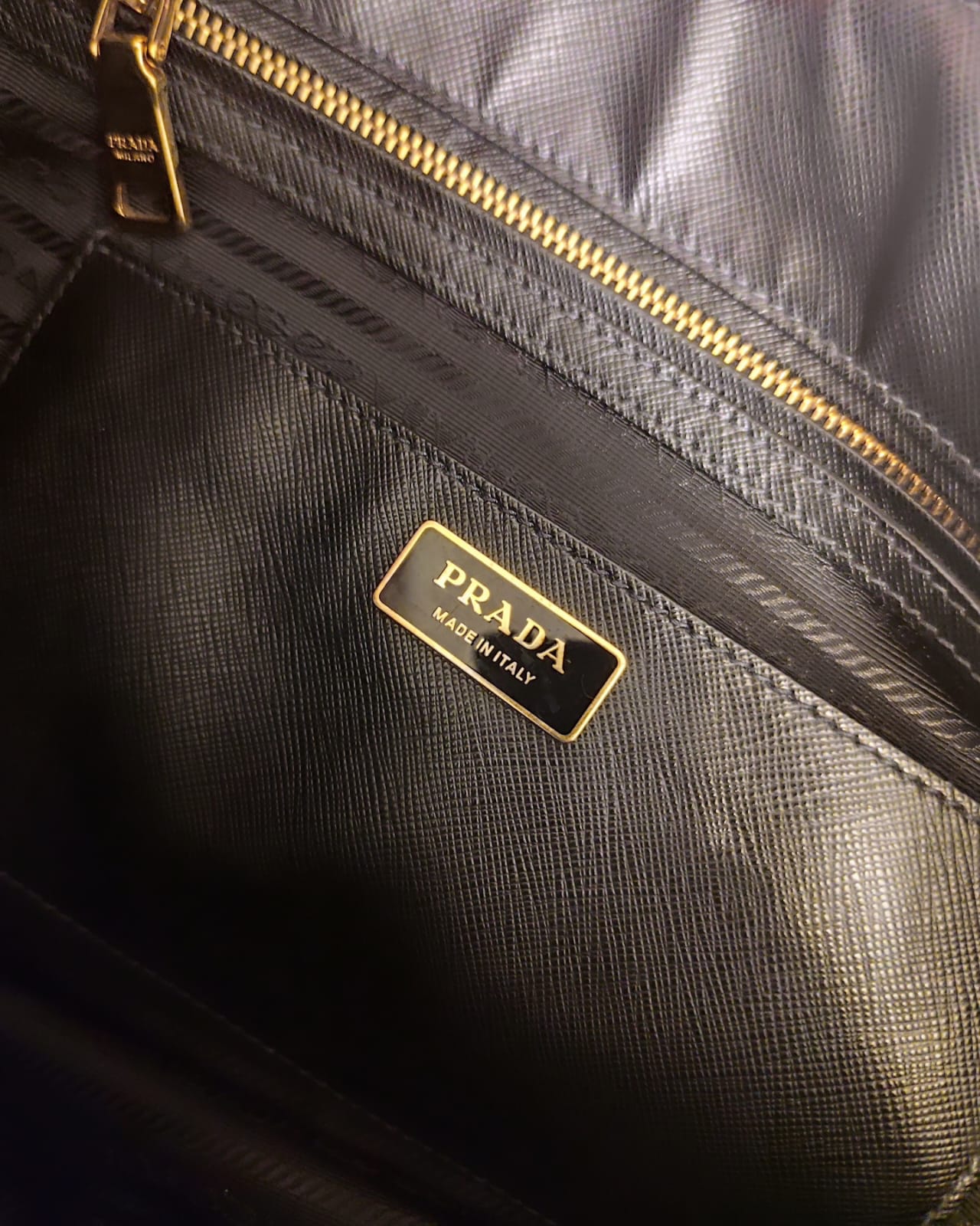 Dettaglio dell’interno della borsa Prada Galleria XL con etichetta metallica PRADA e zip dorata visibile